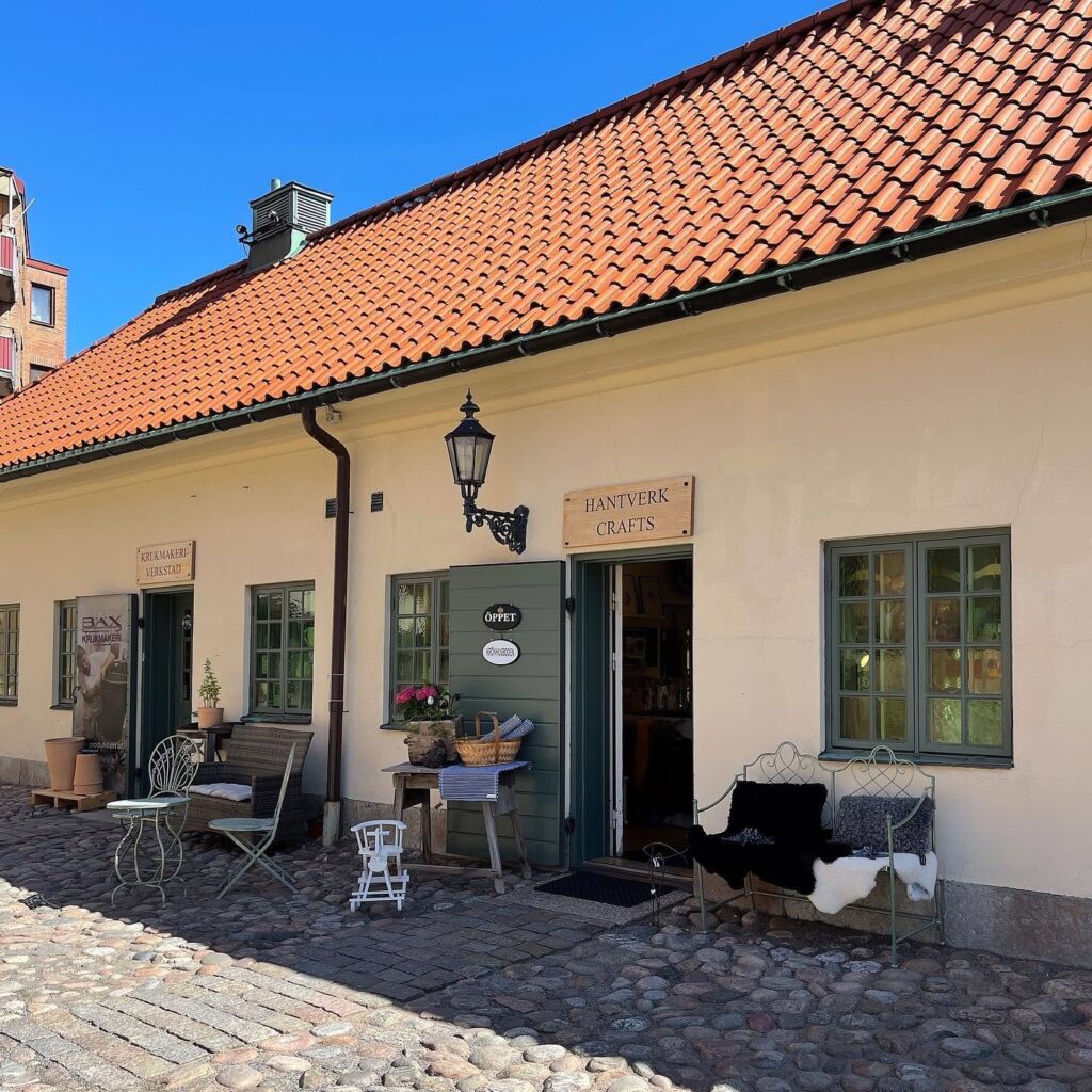 Butiksentrén på Kronhusbodarna med kullersten, tegeltak och skylten Hantverk Crafts